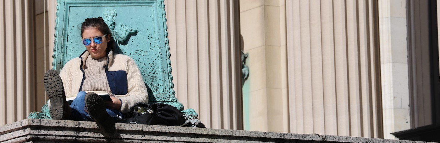 Columbia student studying on steps of Low Library on campus