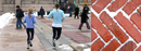 Braving the elements, Columbia University students jog across Low Plaza.