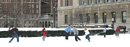 Students play football in the snow in front of Butler Library.
