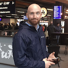 Bald guy in a blue jacket at an airport in Iceland
          holding what appears to be an old phone but, by the crazed look in his eyes, might be a detonator. We should leave...