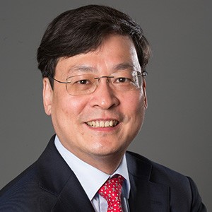 X. Edward Guo, a man with dark hair and glasses, in a dark suit and tie. 