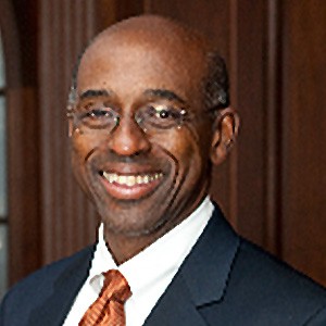 Joseph A. Greenaway, Jr., a man in glasses in a dark suit. 