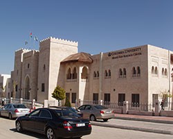 Black car in foreground of a white building in Amman