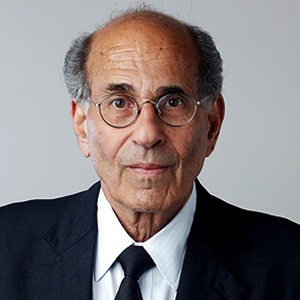 Richard Axel, a man with short hair and glasses, in a dark suit and tie. 