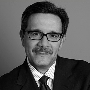 Rolando Acosta, a man with short dark hair in a suit. 