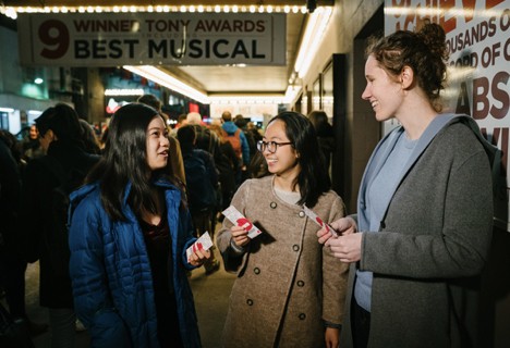 Three women gather to chat while at an arts event