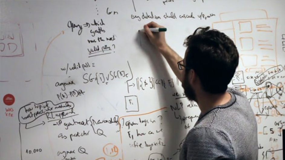 A man scribbles on the whiteboard