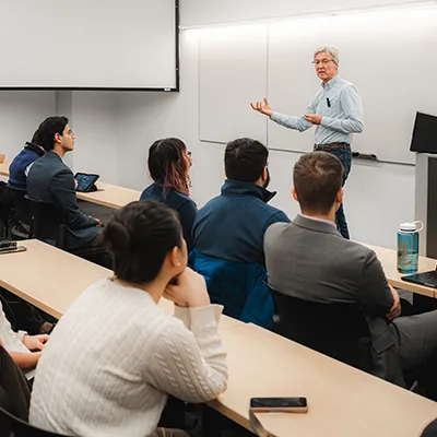 A lecturer talks to a group of students